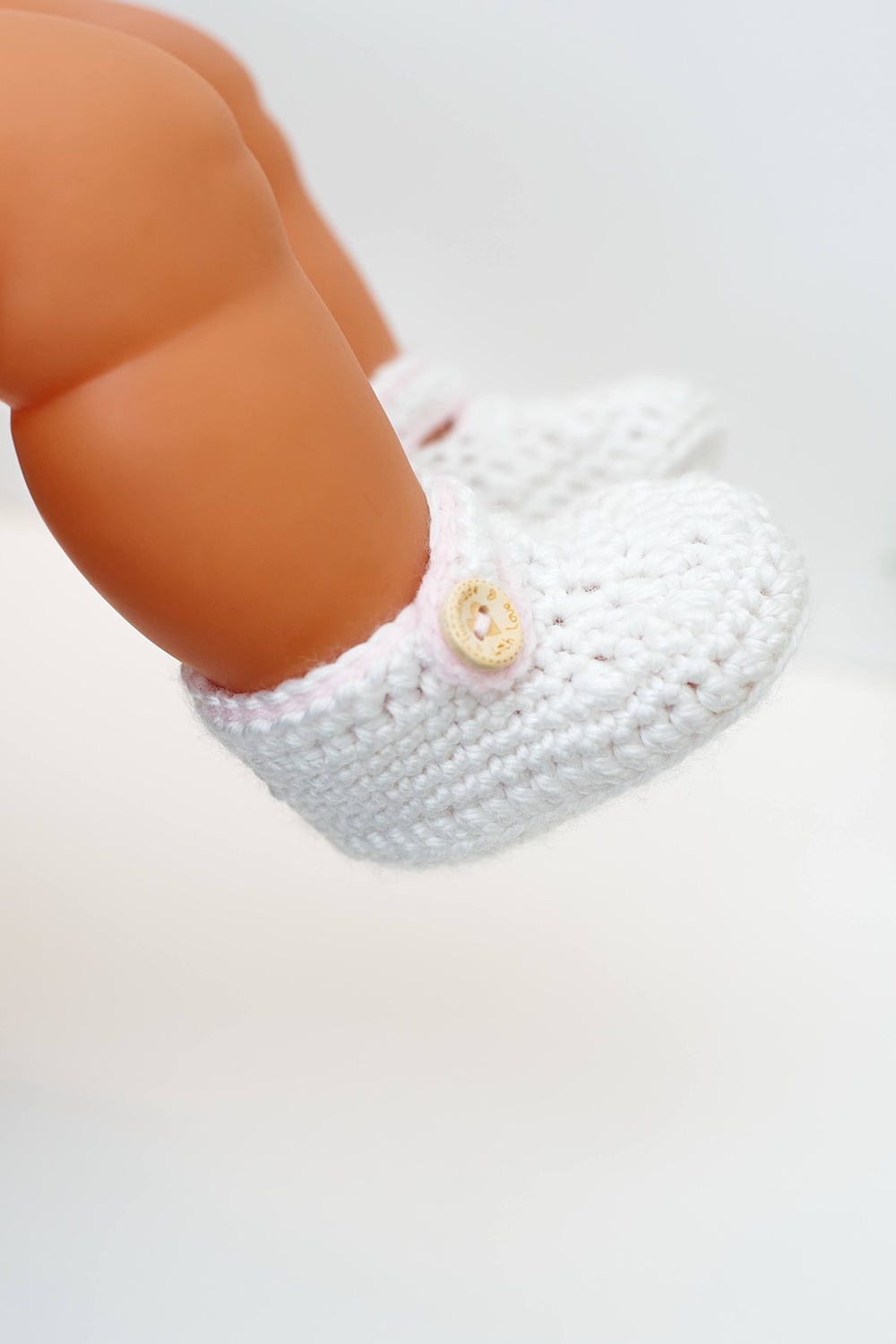 Horgolt fehér babacipő halvány rózsaszín szegéllyel
